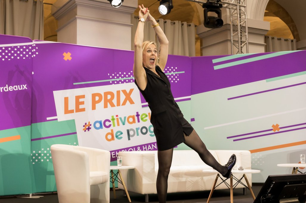 URRH 2023 - Photo de la cérémonie de remise du prix Activateur de progrès, Caroline Leflour est seule sur scène. Elle présente un extrait de son one-woman show "La Chauve Sourit"