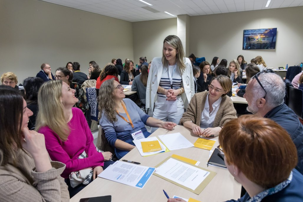 Photo d'un atelier pratique. Des participants sont assis et échangent avec une animatrice de la session.