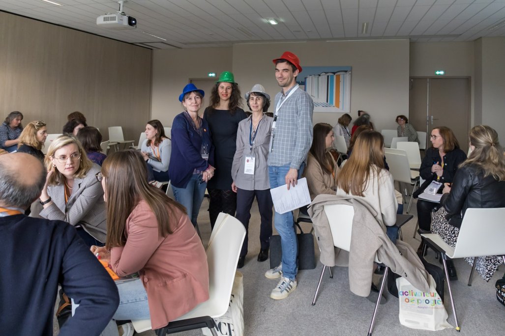 Photo d'un travail en atelier. Les animateurs portent un chapeau.
