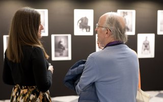 URRH 2023 - Photo de Francesca Clayton à gauche, l'artiste photographe, et à droite, un participant à l'événement. Dans le fond, les photos exposées de l'exposant "Different is Beautiful"