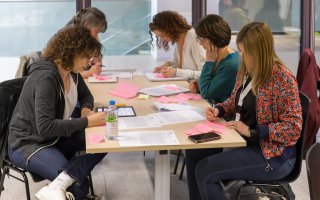 Photo de personnes assises à une table, en train de travailler pendant un atelier.