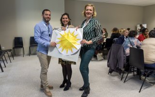 Photo de 3 animateurs d'un atelier, qui tiennent une page de paperboard avec un soleil doré !