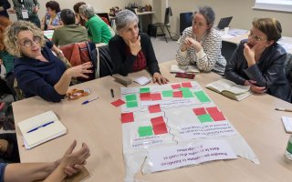 Photo de participants à un atelier, en train de discuter autour d'une table.