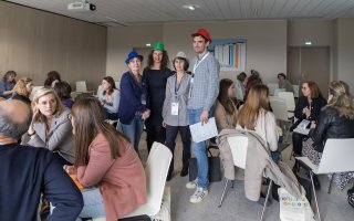 Photo d'un travail en atelier. Les animateurs portent un chapeau.