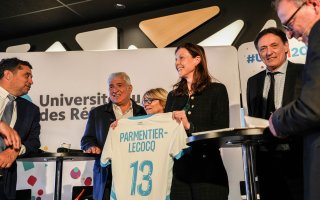 Madame Charlotte Parmentier-Lecocq, Ministre chargée de l'Autonomie et du Handicap, reçoit un t-shirt du Treizième Homme à l'occasion de l'ouverture de l'URRH 2025.