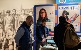 Photo du stand de l'exposant CFlou, avec des personnes qui s'arrêtent devant le stand