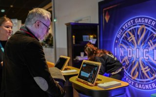 Une personne est devant un écran prêt à jouer à "Qui veut gagner...)