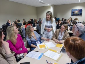 Photo d'un atelier pratique. Des participants sont assis et échangent avec une animatrice de la session.