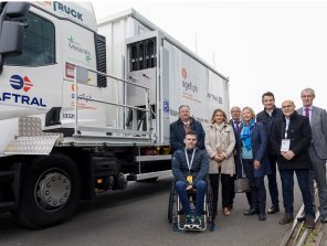 Photo prise de huit personnes debout à droite du camion aménagé pour des personnes en situation de handicap. Sur le camion, apparaissent les logos d'Opco Mobilités, Aftral et Agefiph.