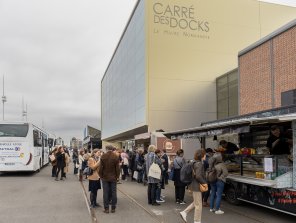 Photo de 2 foodtrucks présents à l'URRH : La Rôtisserie des 4 saisons et Conteneur à burger. Une petite foule attend d'être servi.