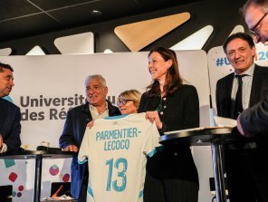 Madame Charlotte Parmentier-Lecocq, Ministre chargée de l'Autonomie et du Handicap, reçoit un t-shirt du Treizième Homme à l'occasion de l'ouverture de l'URRH 2025.