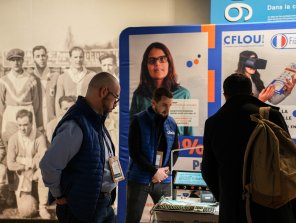 Photo du stand de l'exposant CFlou, avec des personnes qui s'arrêtent devant le stand