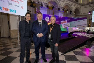 URRH 2023 - Photo de la cérémonie de remise du prix Activateur de progrès, hors scène. Au centre, Christophe Roth, Président de l'Agefiph entouré de deux participants del'événement.