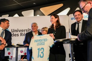 Madame Charlotte Parmentier-Lecocq, Ministre chargée de l'Autonomie et du Handicap, reçoit un t-shirt du Treizième Homme à l'occasion de l'ouverture de l'URRH 2025.