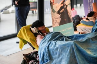 Deux personnes sont semi-allongées, avec un casque sur les oreilles et des lunettes sur les yeux, pour une séance de luminothérapie