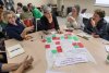 Photo de participants à un atelier, en train de discuter autour d'une table.