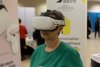 Photo d'une participante qui test un casque de réalité virtuelle, dans l'espace exposant. Sur le stand de Bbird.